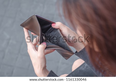 Unhappy bankrupt woman with empty wallet . Young woman shows her empty wallet. Bankruptcy
