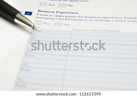 Pen and application form for business experience that requires to fill out his required information.