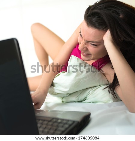 Young adult woman with laptop on the bed