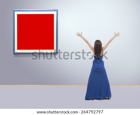 Woman standing inside a gallery in front of picture frames with hands up. Film grain is added for better impression  NOTE:This image is composite of more photos.