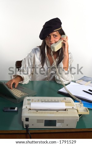 Businesswoman with cap talking on phone at the office
