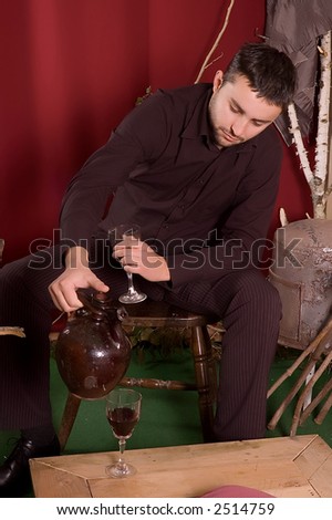 Young man drinking red wine at retro enterior for valentine day