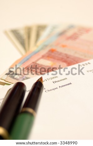 Cheque, money and pen, focus on first plane