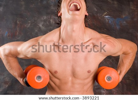 Muscular builder man training his body with dumbbell