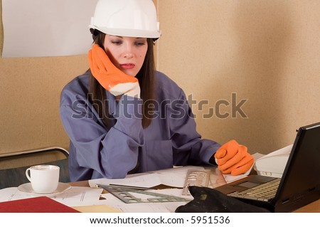 Woman engineer with helmet on head and arch project at table