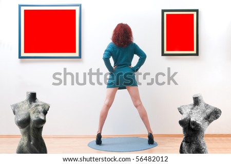 Woman posing inside a gallery infront of two picture frames with two torso female sculpture