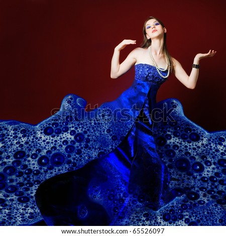 Woman dressed in blue soap bubble evening garment, grain added