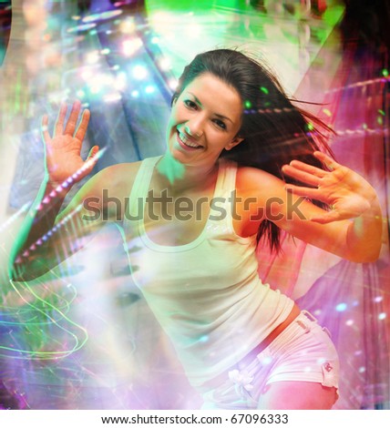 Young woman dancing at night club and looking at camera with smile