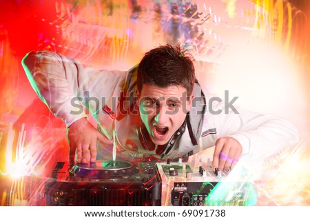 Disc jockey spinning and mixing records at night club