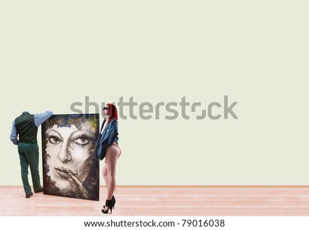 Sexy woman and man without head standing at gallery, holding  oil image and looking at blank walls around its