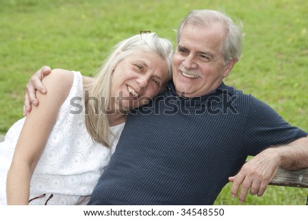 A happy couple in their early retirement years relaxes outdoors.