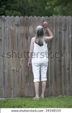 A nosy neighbor thinks about how she will get a peek over the fence.