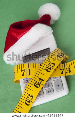 Calculator with a Santa Hat squeezed by a measuring tape representing a tight holiday budget.