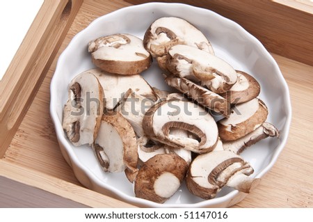 Mushroom Slices in a Dish Shown in a Wooden Tray Ready to Cook With.
