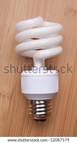 Fluorescent Light Bulb on a Wood Background.
