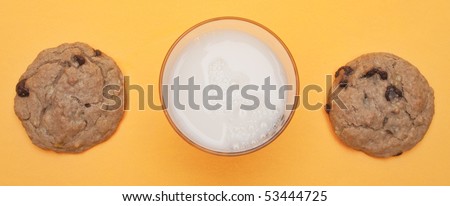 Snack of Banana Chocolate Chip Cookies and a Glass of Milk on a Yellow Background.