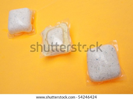Packets of Dishwasher Detergent on a Modern Vibrant Yellow Background.