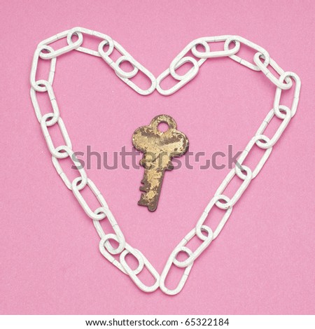 Key to My Heart Love and Security Concept with Chain Heart and Old Key on a Pink Background.