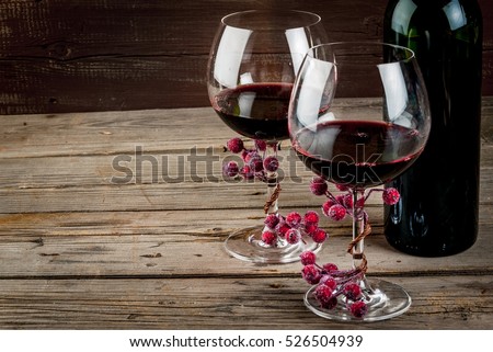 Bottle of wine and two glasses of wine, decorated with artificial branch of winter berries. The festive mood, Valentine\'s Day, Thanksgiving or Christmas. Copy space.