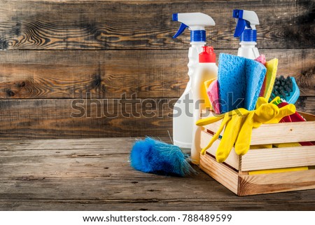 Spring cleaning concept with supplies, house cleaning products pile. Household chore concept, on rustic or garden wooden background copy space