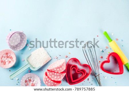 Sweet baking concept for Valentine\'s day,  cooking background with baking - with a rolling pin, whisk for whipping, cookie cutters, sugar sprinkling, flour. Light blue background, top view copy space