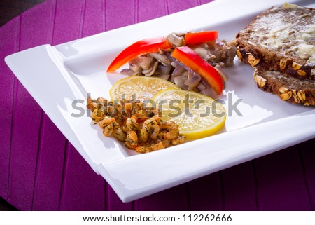 Starter with fried prawns with lemon, mushrooms and brown bread