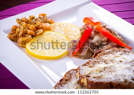 Starter with fried prawns with lemon, mushrooms and brown bread