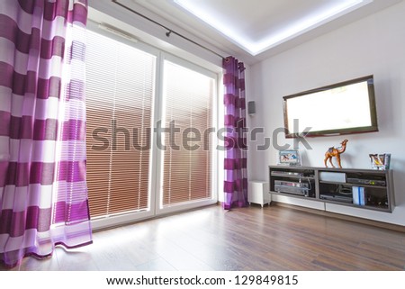 Modern white living room interior with purple curtains