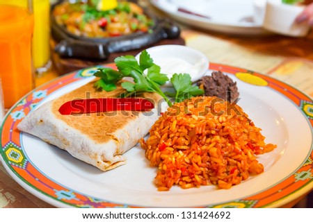 Mexican burritos with beef, melted cheese and rice