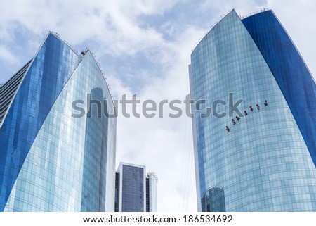 ABU DHABI, UAE - MARCH 25: Window cleaners working on the Etihad Tower in Abu Dhabi on March 25, 2014, UAE. Five towers complex with 74 floors is the third tallest building in Abu Dhabi.