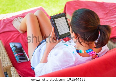 Woman reading on electronic book on summer holidays