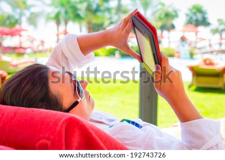 Woman reading on electronic book on summer holidays