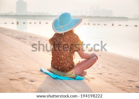 Woman at sunrise meditation on the beach