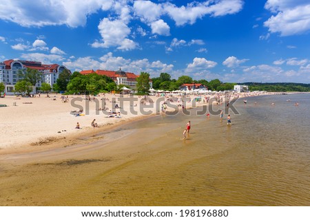 SOPOT, POLAND - 7 JUNE: People on the beach of Sopot at the Grand Hotel on 7 June 2014. Grand hotel built in 1924Ã¢Â?Â?1927 is the most refined hotel in Sopot - major health and tourist resort destination.