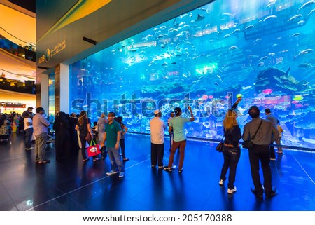 DUBAI, UAE - 1 APRIL 2014: People in front of the Oceanarium inside Dubai Mall. It is the largest indoor aquarium in the world at a length of 50 meters long and 10 million litres of water.