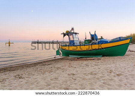 Baltic beach with fishing boat at sunset, Poland