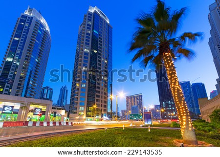 DUBAI, UAE - MARCH 30, 2014: Illuminated skyscrapers of Dubai Marina at night, United Arab Emirates. Dubai Marina is a district with artificial canal city who accommodates more than 120,000 people.