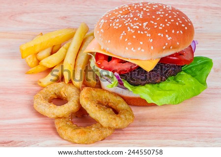 Cheeseburger with lettuce, tomato and onion rings