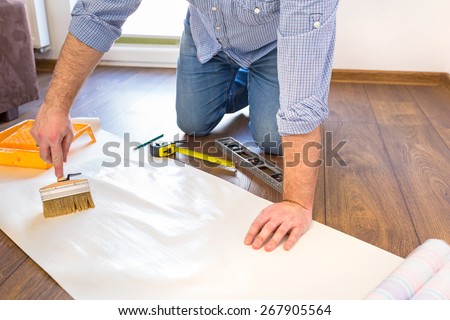 Handyman applying blue for a wallpaper