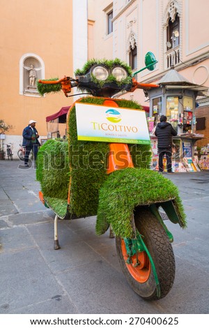 PISA, ITALY - APRIL 11, 2015: Old style bike covered with grass on the street of Pisa in Italy. Pisa is a city in Tuscany known worldwide for the Leaning Tower, one of the biggest landmark.