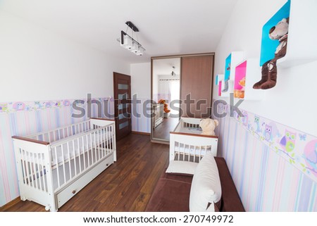 Bright baby room with pastel wallpapers and white cradles