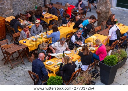 CORNIGLIA, ITALY - APRIL 12, 2015: Unidentified people eating traditional italian food in outdoor restaurant of Corniglia, Italy. Corniglia is one of five famous coastline villages in the Cinque Terre