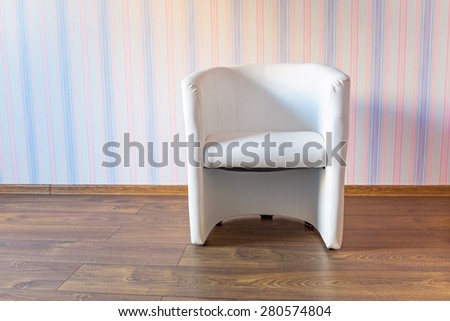 White armchair in the room with pastel wallpapers