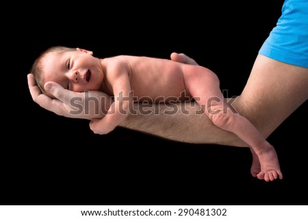 Newborn twins on hands over black background