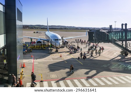 GDANSK AIRPORT, POLAND - 10 APRIL 2015: People boarding to Ryanair plane on Lech Walesa Airport in Gdansk. Ryanair operates over 300 aircraft and is the biggest low-cost airline company in Europe.