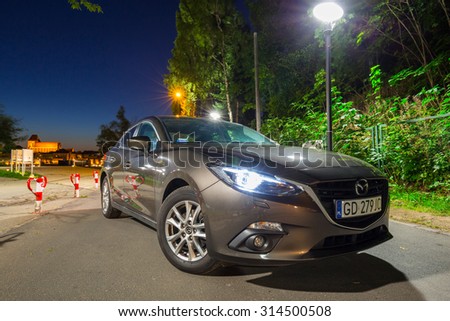 POLAND-AUGUST 9, 2015: New Mazda 3 captured at dusk with long exposure technique. Mazda 3 is a popular compact car manufactured in Japan by the Mazda Motor Corporation.
