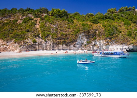 ZAKYNTHOS, GREECE - AUG 24, 2015: Boats with tourists at the Blue caves of Zakynthos island, Greece. Sunrays reflect through blue sea water from white limestones creating visual lighting effects.