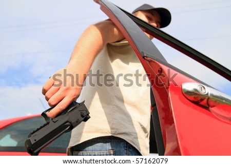 Man holding gun entering to red car