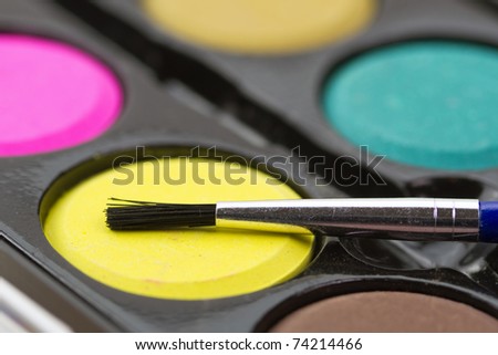 Closeup of a palette of watercolor paints with brush.
