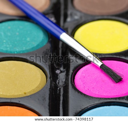 Closeup of a palette of watercolor paints with brush